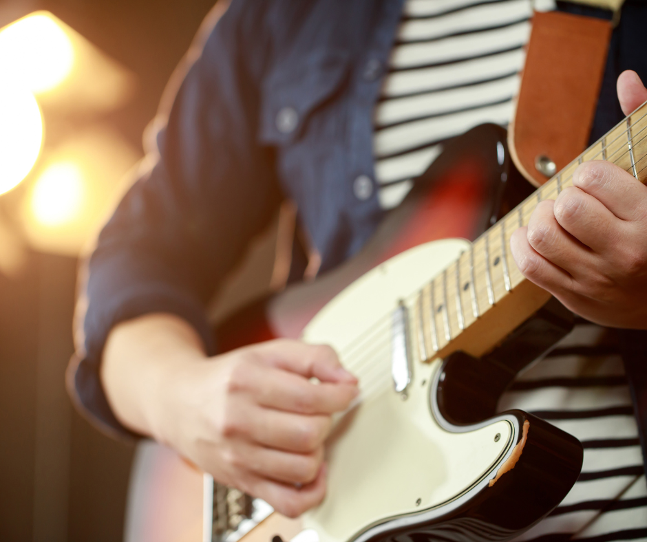 VMD Web Images Someone in a striped T-shirt playing an electric guitar.