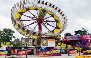 Colourful funfair rides mid-motion.